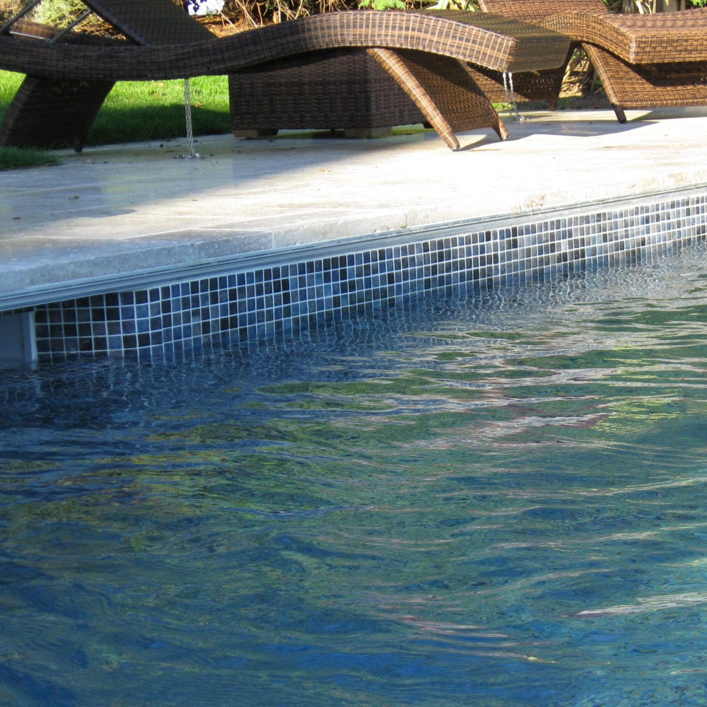 Mosaic tiled outdoor pool finish with simple paving coping