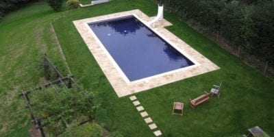 Aerial Shot of Swimming Pool with Paving and Slide