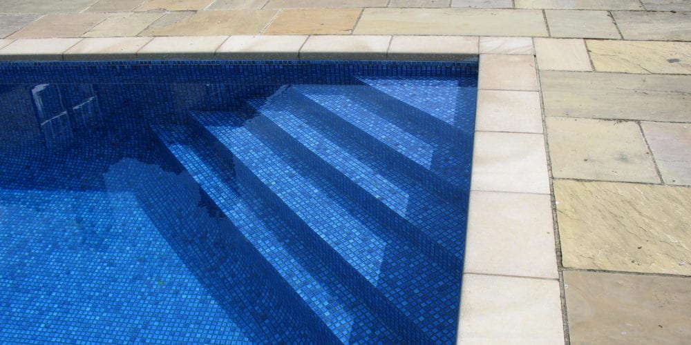Corner steps of swimming pool with blue mosaic tile
