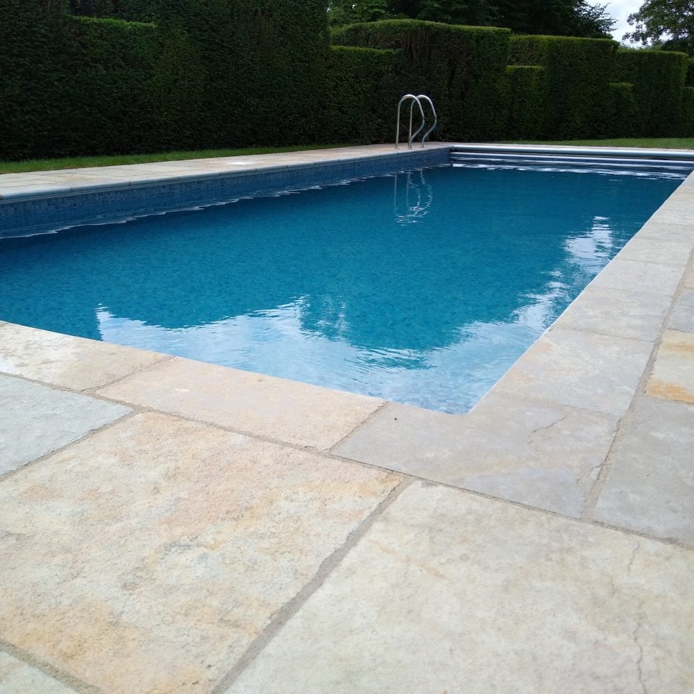 Outdoor swimming pool in Surrey with mosaic tile and grabrail