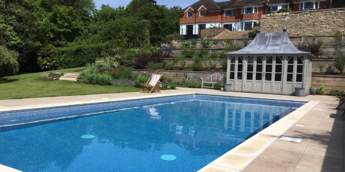Outdoor pool installation with new coping and pool house