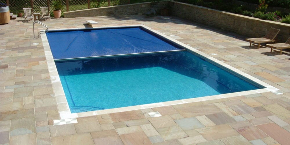Outdoor swimming pool in Surrey with half-closed cover